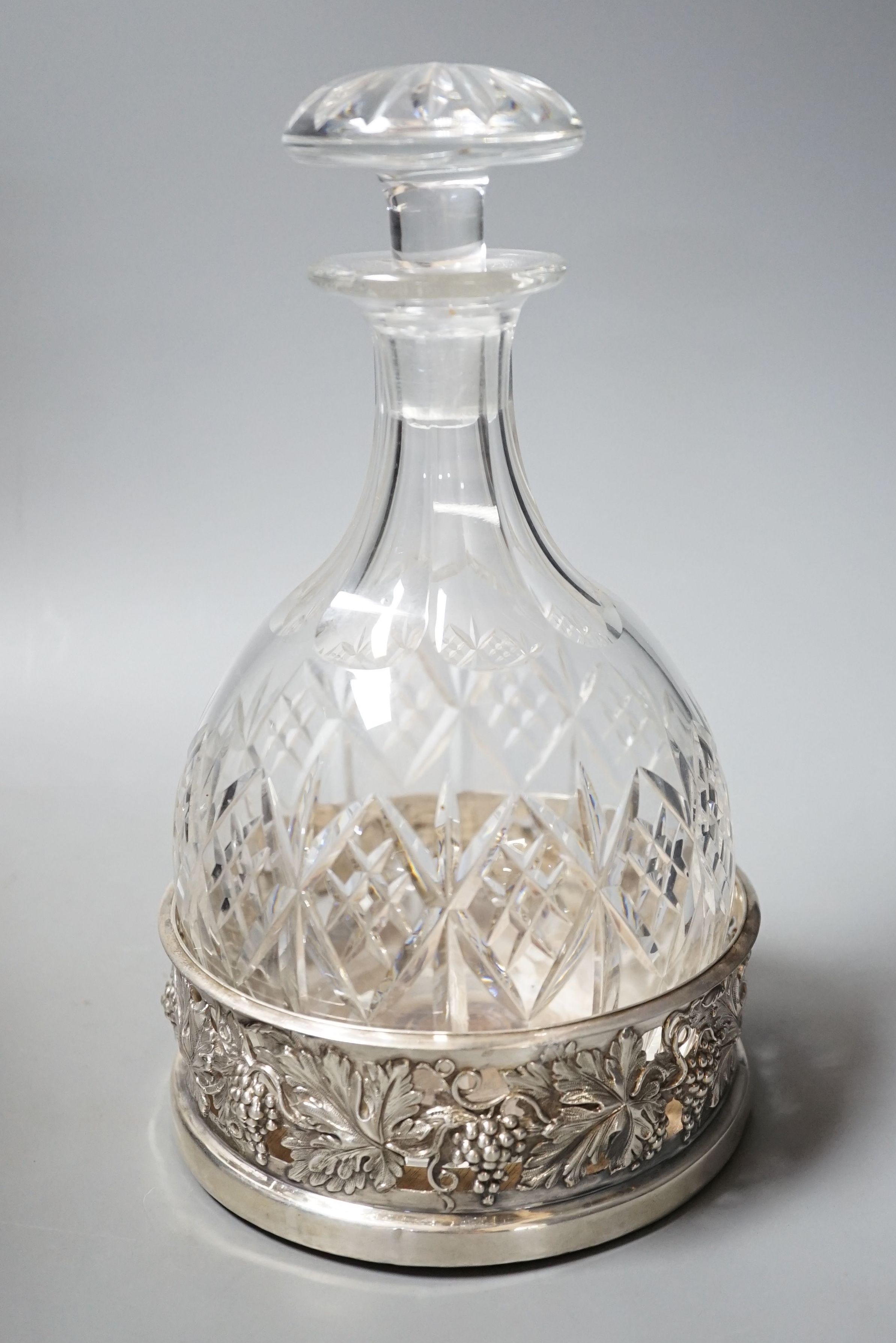 A William IV pierced silver mounted wine coaster, with fruiting vine decoration, Howard, Battie & Hawksworth, Sheffield, 1833, 13.9cm(repair), together with a cut glass decanter.
